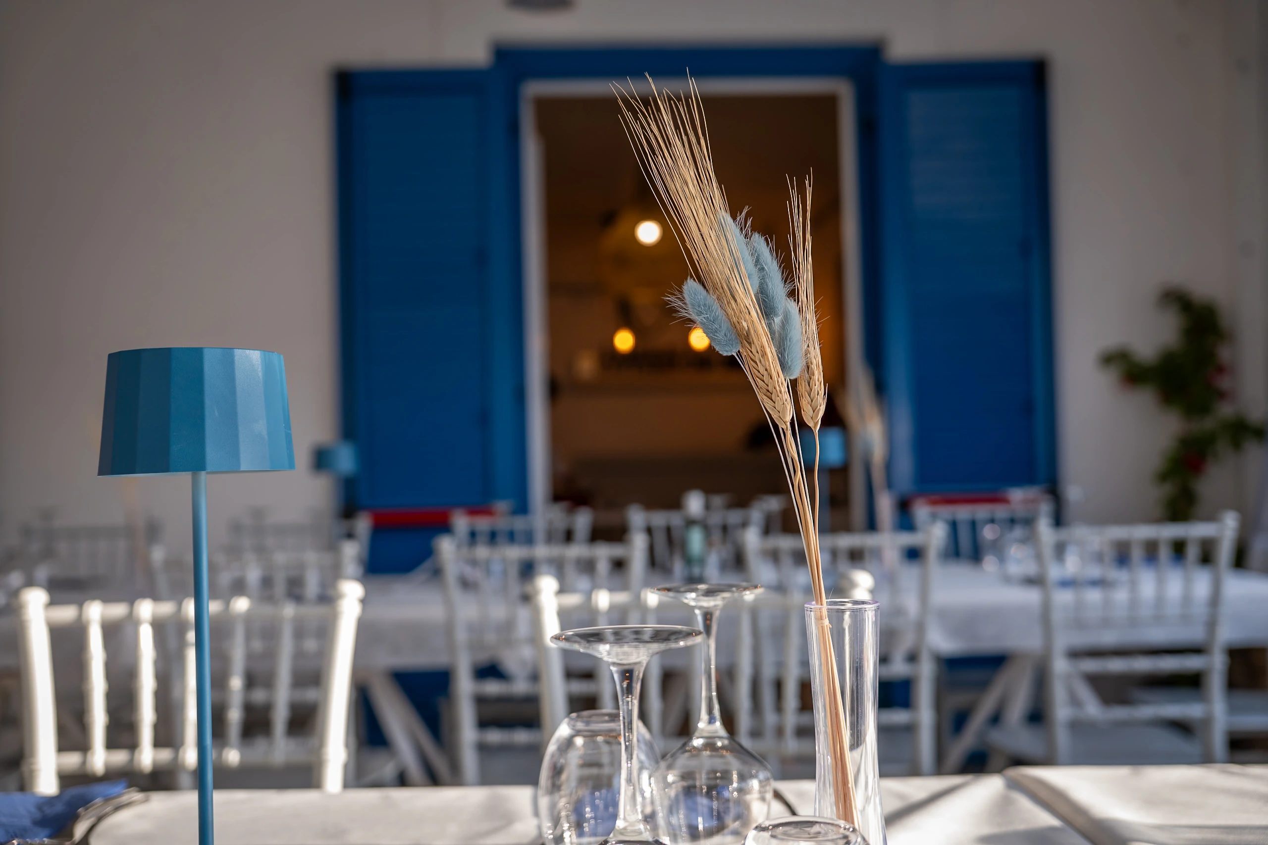 Tavolo apparecchiato e persiane blu al ristorante Poseidon
