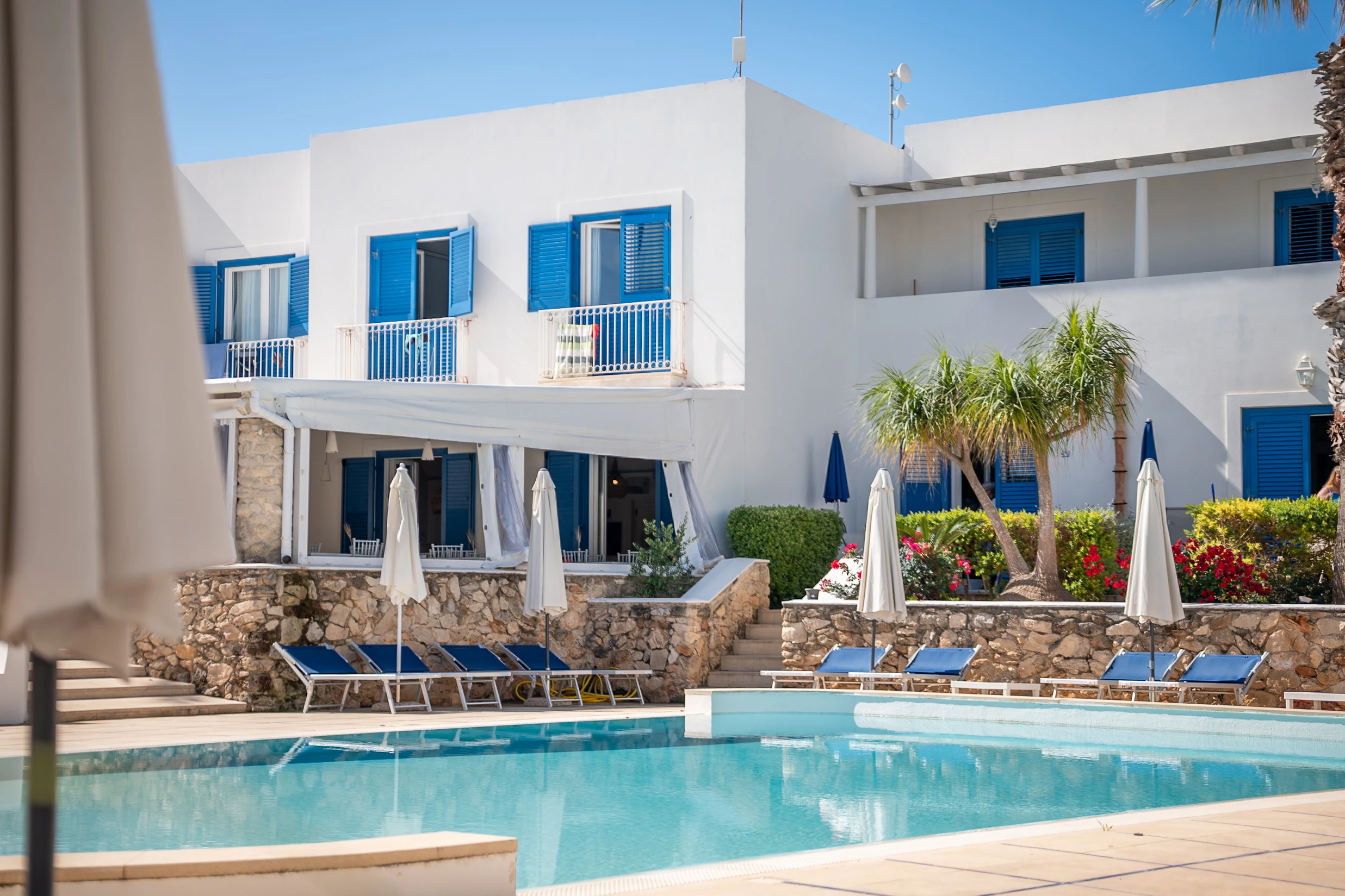 Piscina e facciate bianche con infissi blu di Cala La Luna