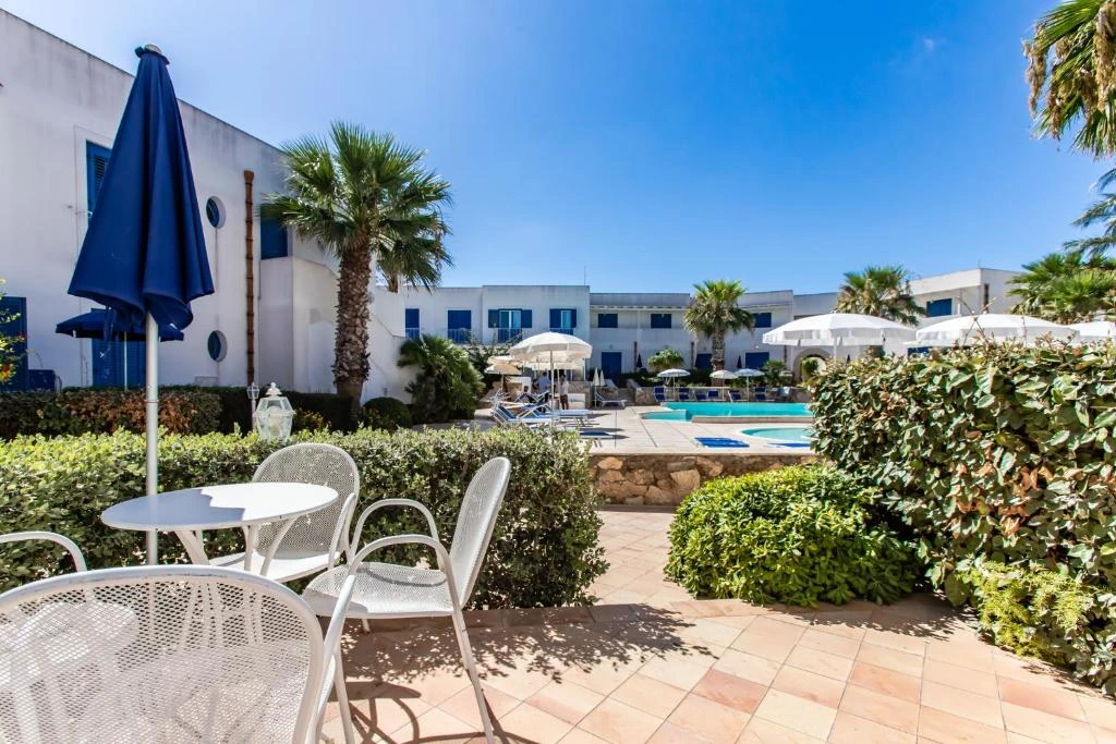 Tavolini sulla terrazza del resort affacciati sul giardino e sulla piscina