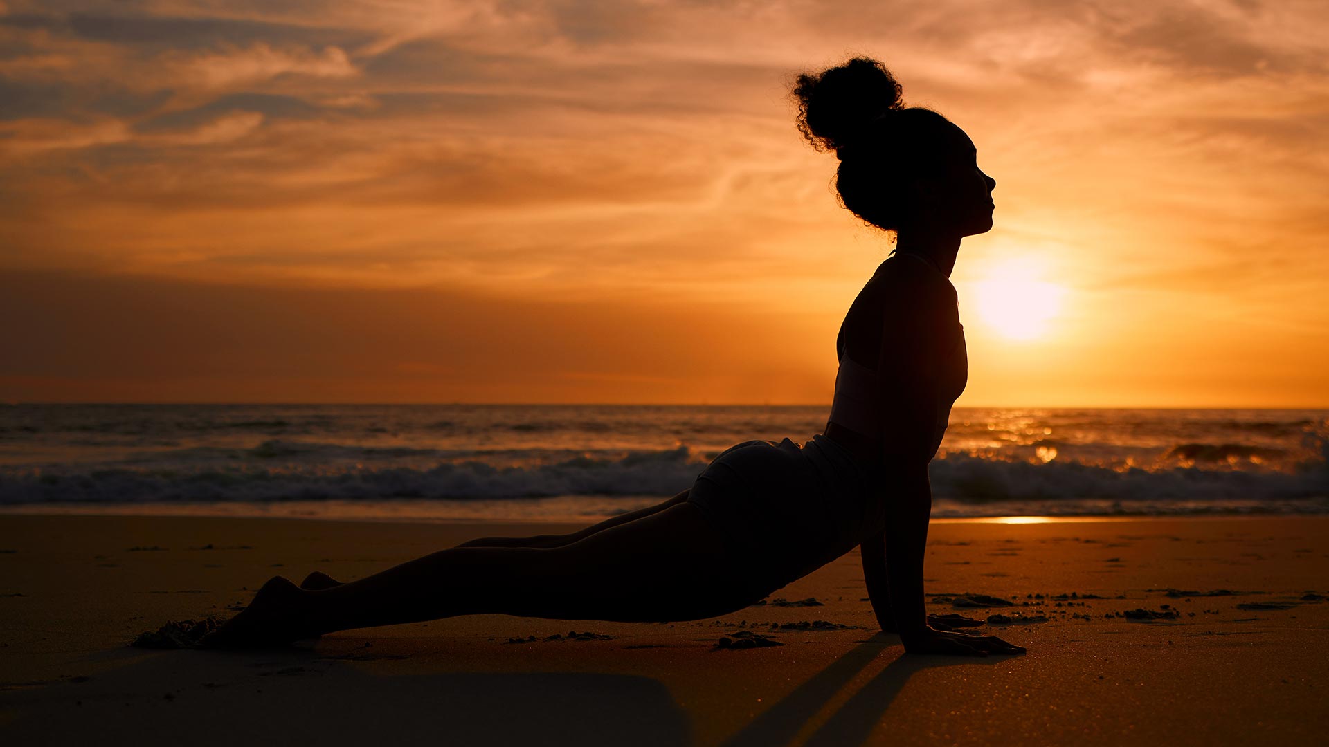 Yoga sulla spiaggia al tramonto